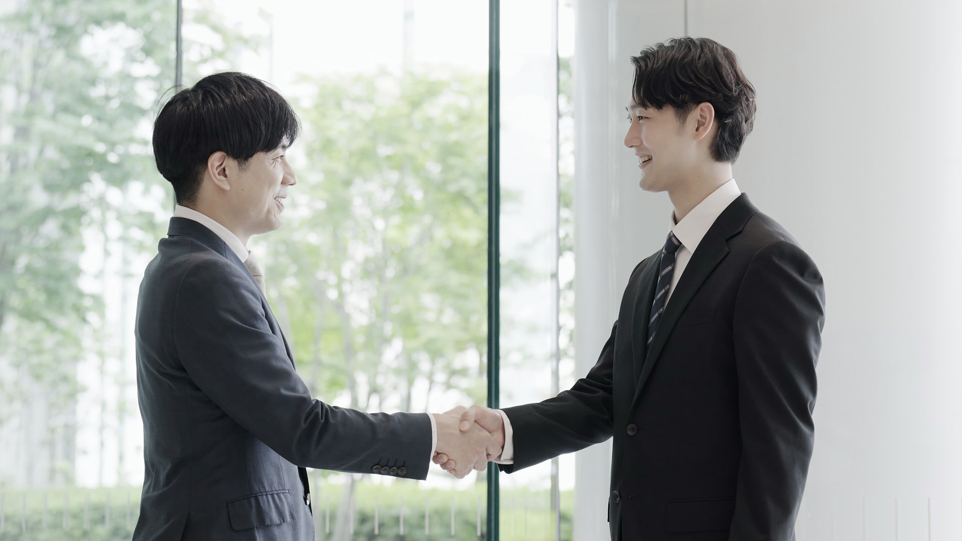 asian-businessmen-shaking-hands-in-a-lobby-2025-03-16-20-11-22-utc - Fujiarte.com